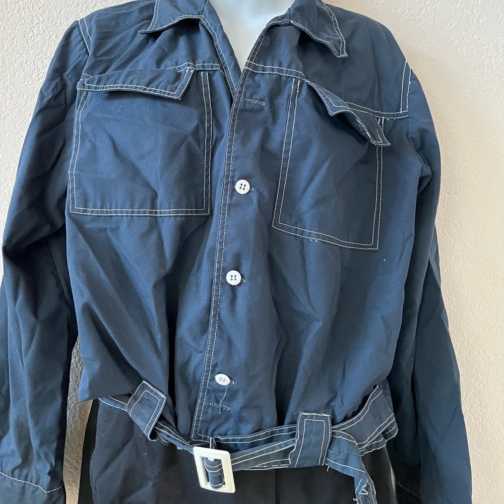 A Jacket that closes with buttons and a belt
